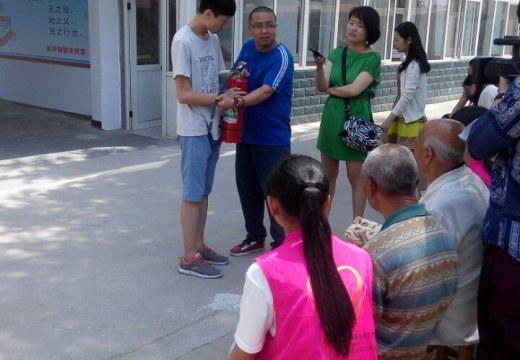 苗老師與志愿者為老人們演示講解滅火器的使用方法