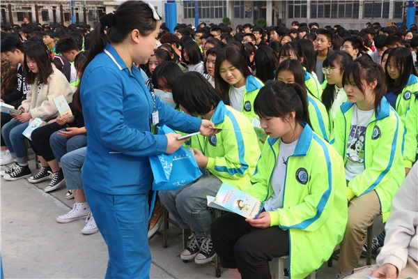 工作人員為學生分發(fā)傳染病防治知識手冊.JPG