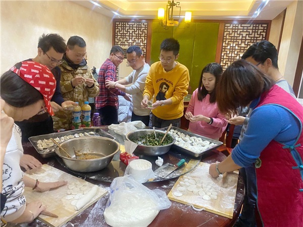 3青年教師圍在一起包餃子.jpg