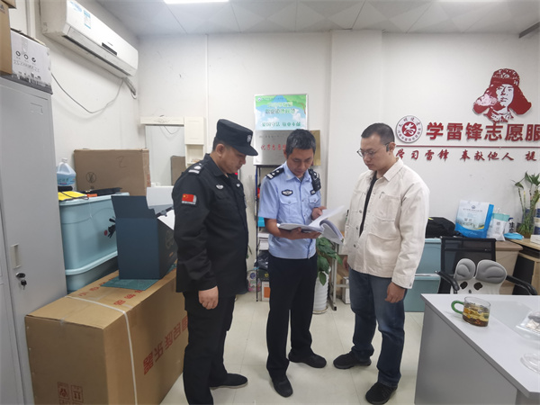 郭警官檢查學(xué)校安全材料.jpg